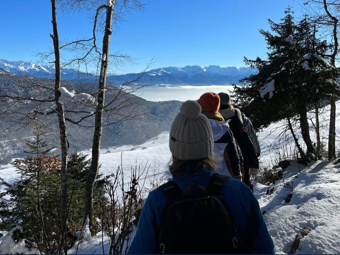Randonnée en raquettes dans la montagne enneigée, avec vue sur les sommets.